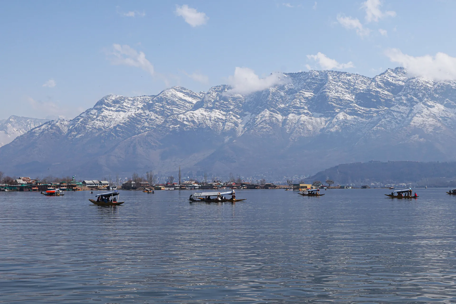 Shikaras on Dal Lake with the majestic Himalayas in the background.