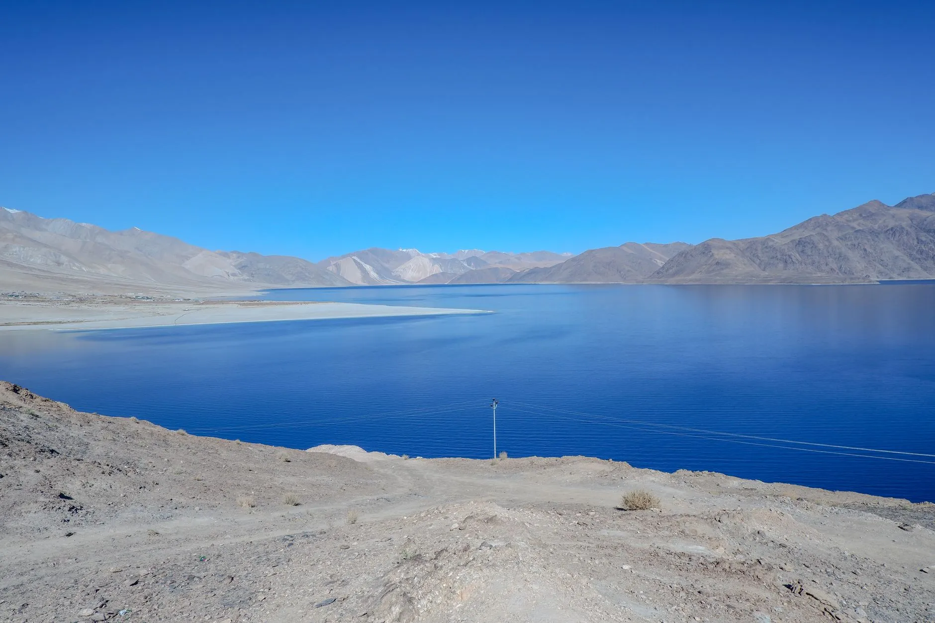 Captivating view of Pangong Lake with clear blue skies and mountain backdrop.
