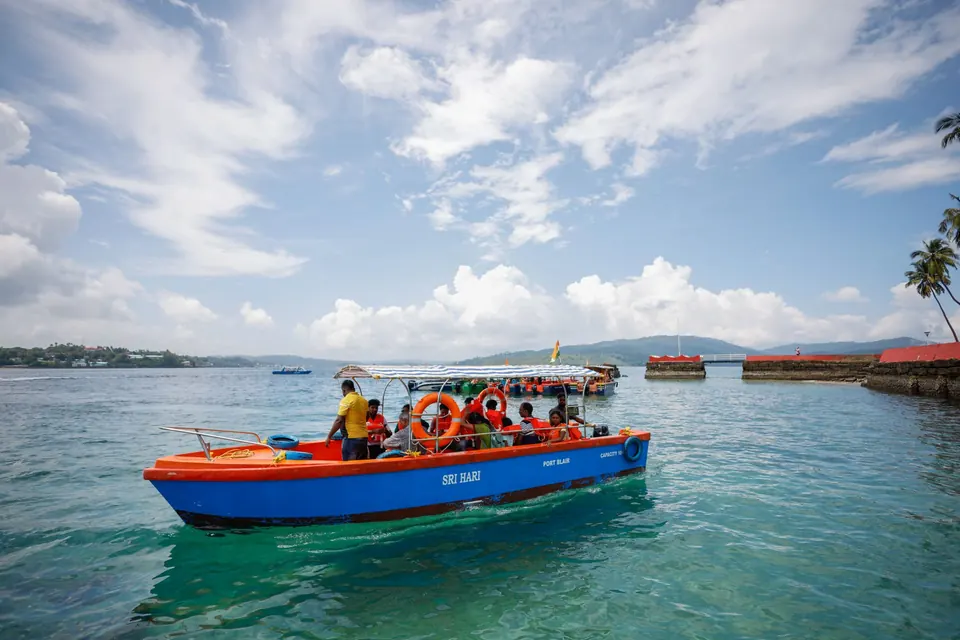 Vibrant boat docked in serene blue waters under a clear sky in Port Blair, perfect for travel and tourism concepts.