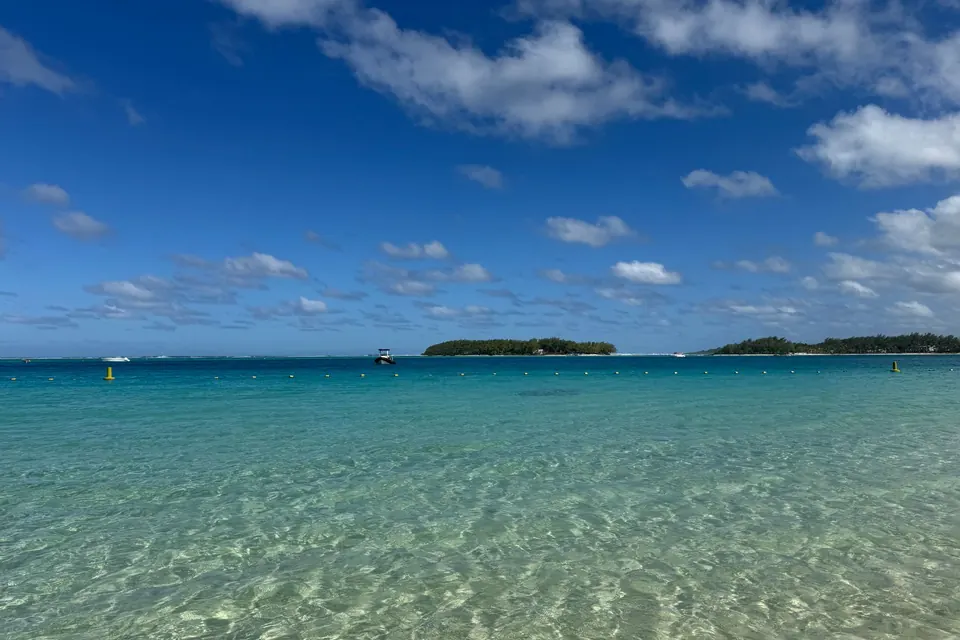 Crystal clear waters at Blue Bay, Grand Port District, Mauritius under a vibrant blue sky.