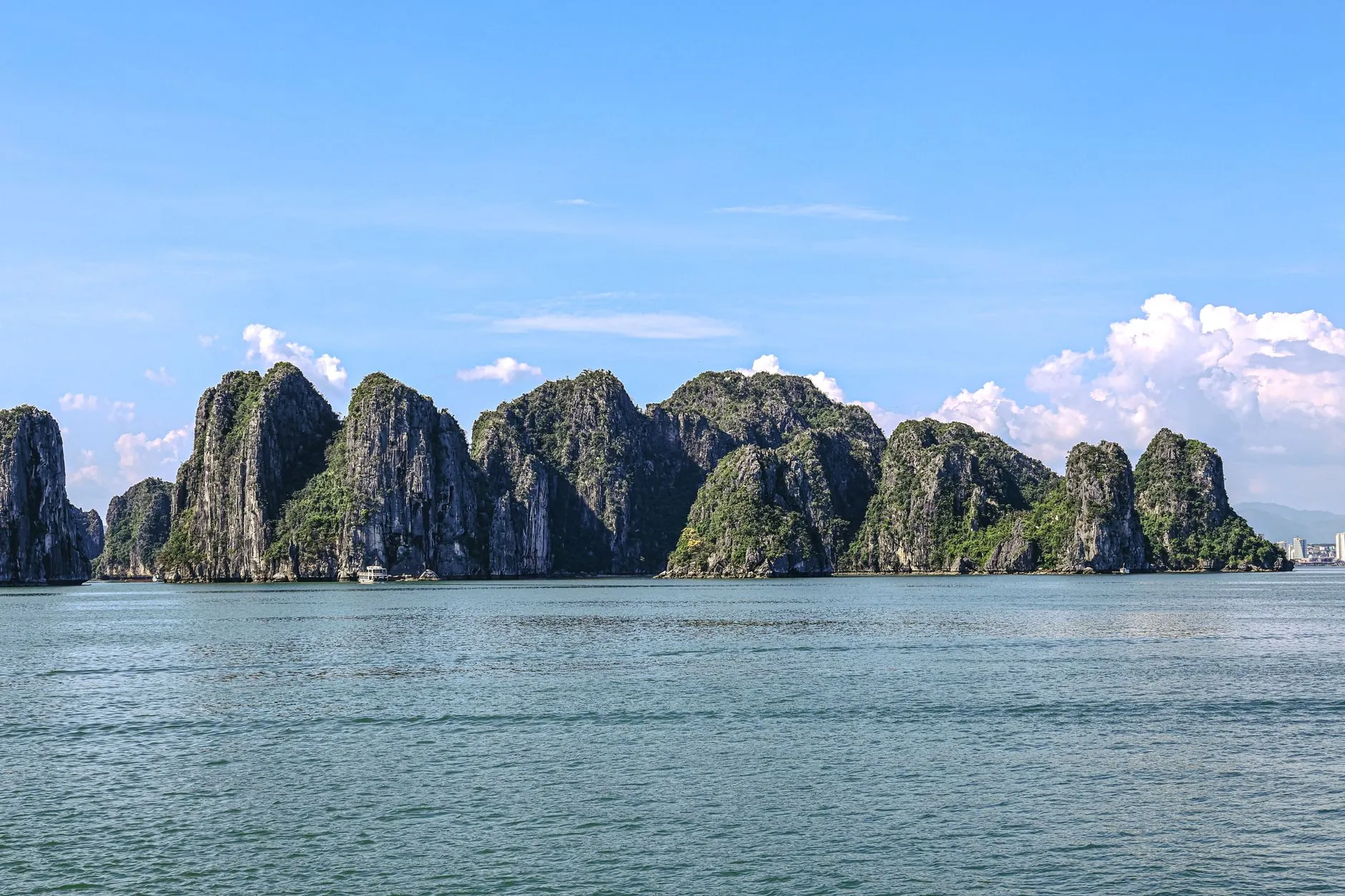 Stunning capture of Ha Long Bay's iconic limestone karsts under a clear blue sky.