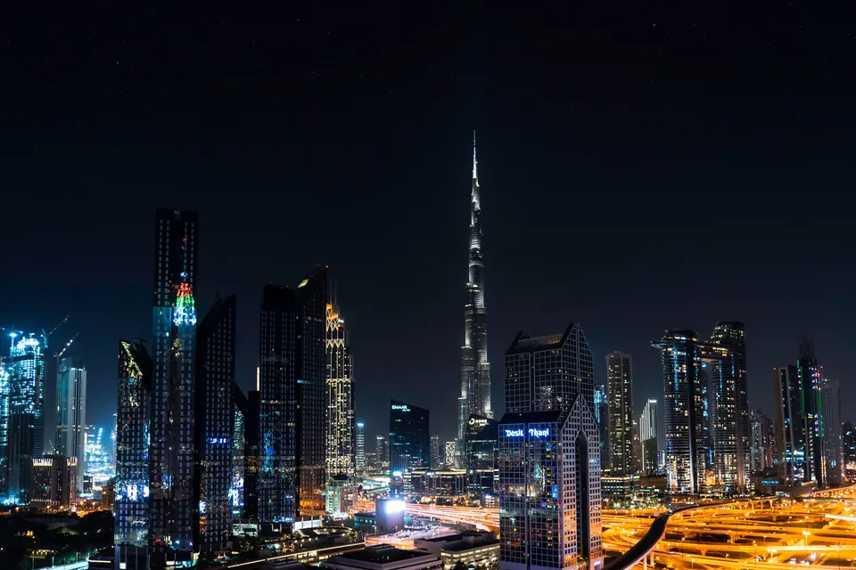 Stunning nighttime view of Dubai's skyline with the iconic Burj Khalifa illuminated under a starry sky.