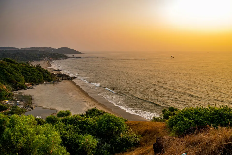 The sun is setting over the ocean and a beach.