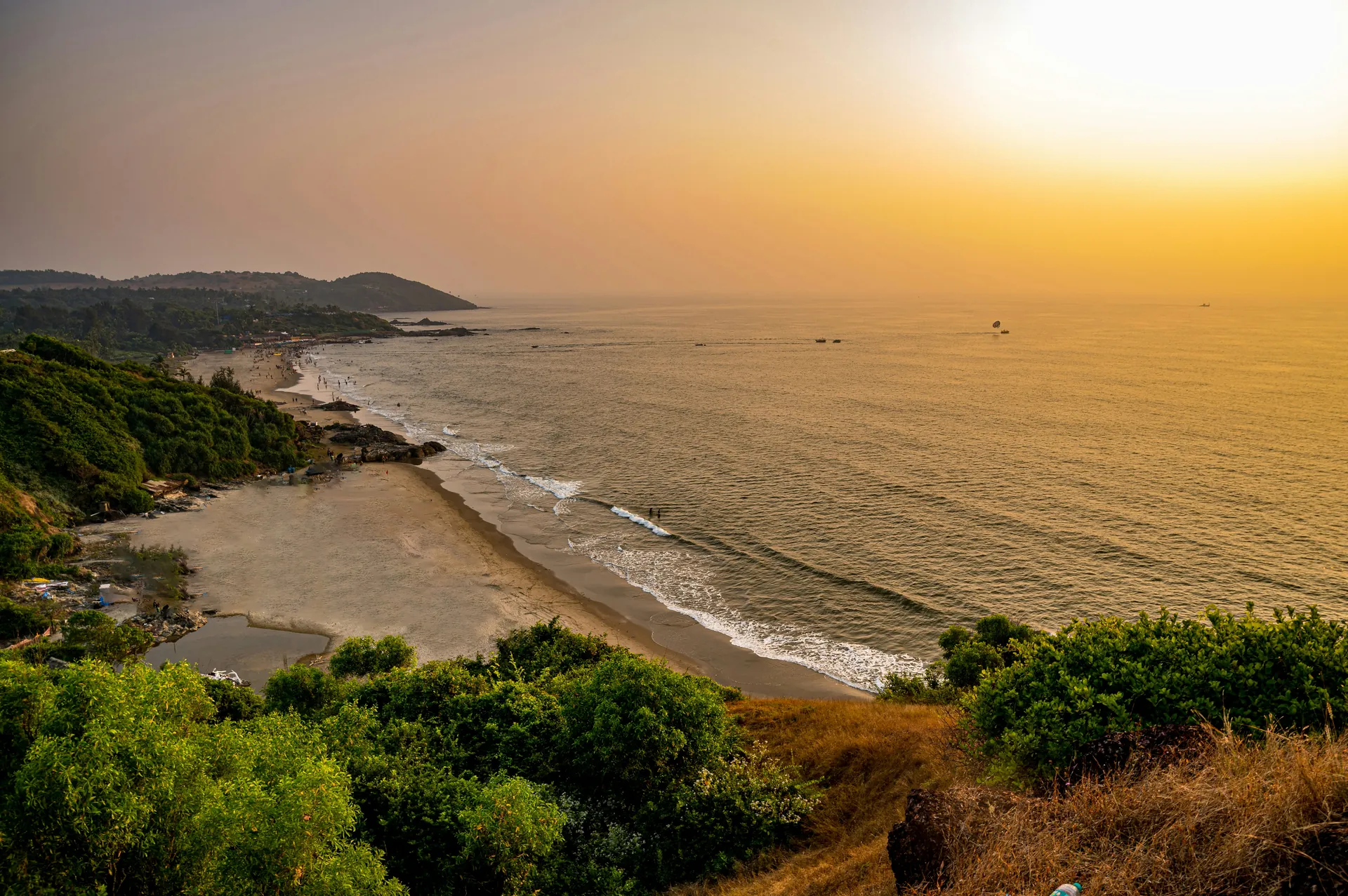 The sun is setting over the ocean and a beach.